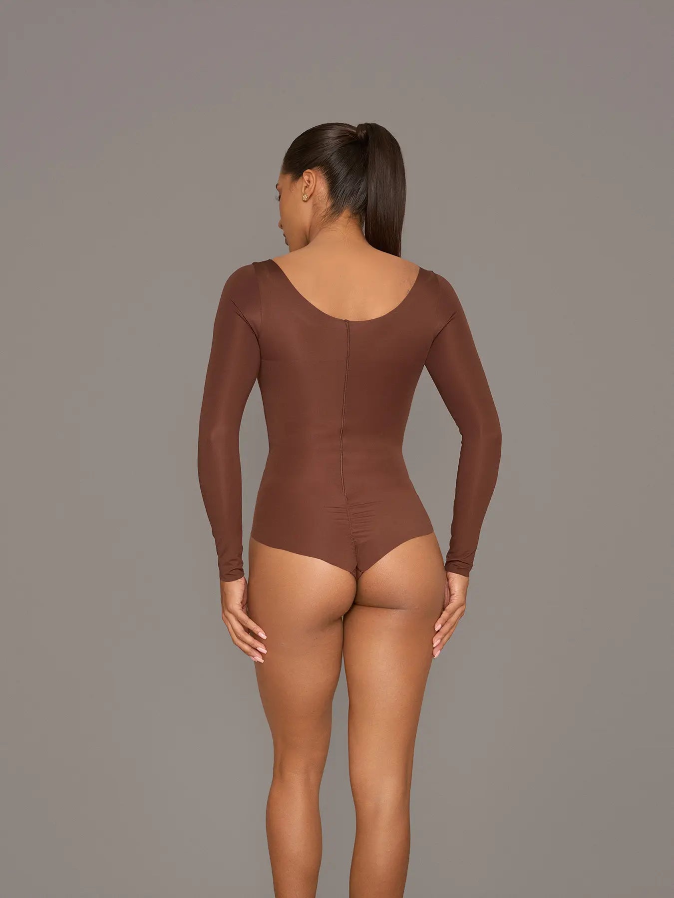 Vista posterior de modelo utilizando el body manga larga color chocolate