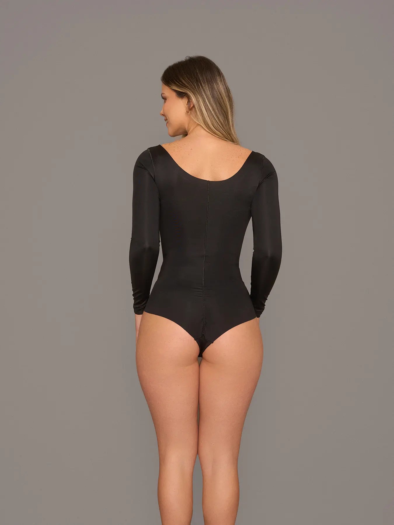 Vista posterior de modelo utilizando el body manga larga color negrio